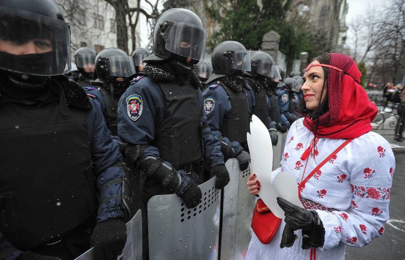 Украинская девушка позирует на фоне силовиков, Киев, на рубеже 2013-2014 годов.