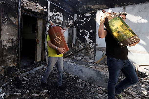 12 мая 2021 года. Евреи эвакуируют свитки Торы из сожжённой синагоги в г. Лоде