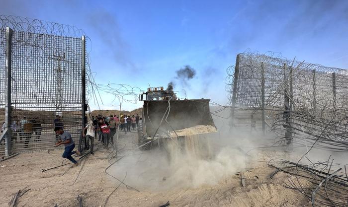 Палестинцы на бульдозере проламывают защитные ограждения израильтян