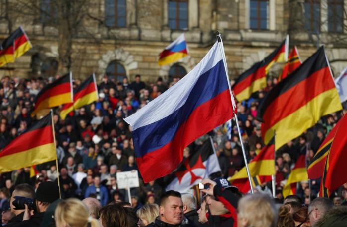 Российские и германские флаги на митинге в Берлине